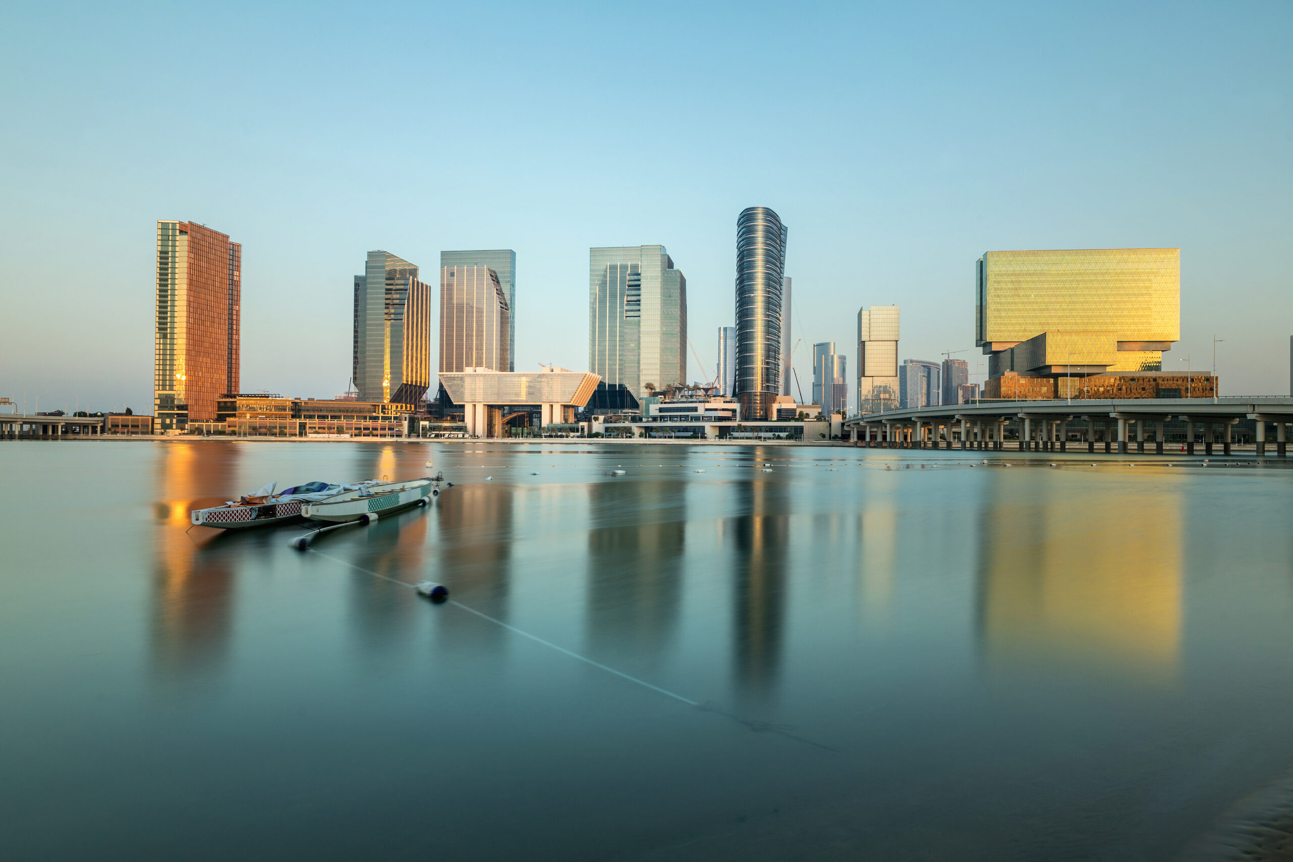 Al Maryah Island skyline at dusk. Abu Dhabi, United Arab Emirates, Skyscrapers illuminated by the setting sun in gold, Abu Dhabi, Emirates