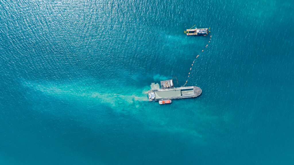 Aerial top view of Vessel engaged in dredging. Hopper dredger working at sea. Ship excavating material from a water